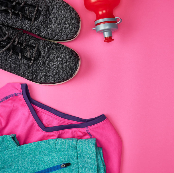 αθλητικά υποδήματα κλωστοϋφαντουργίας και άλλα αντικείμενα για την καταλληλότητα σε ένα ροζ πίσω - Φωτογραφία, εικόνα