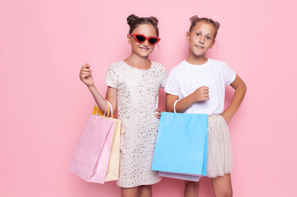 Two smiling teenage girls hold bags in their hands after a shopping trip - Zdjęcie, obraz