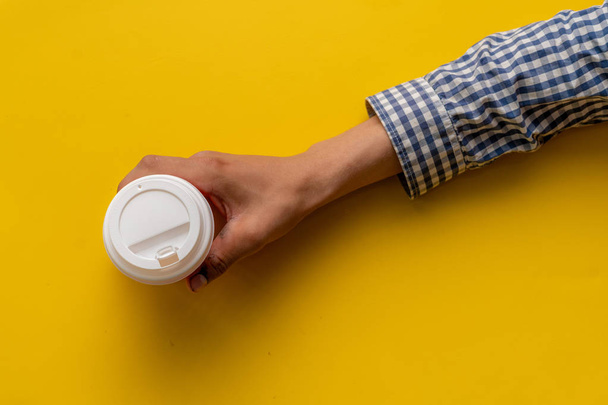 pohled na ruce s odpracením papírového šálku kávy - Fotografie, Obrázek