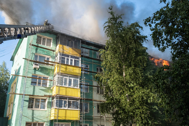 Toit en feu d'un immeuble résidentiel de grande hauteur, nuages de fumée provenant du feu. vue de dessus
 - Photo, image