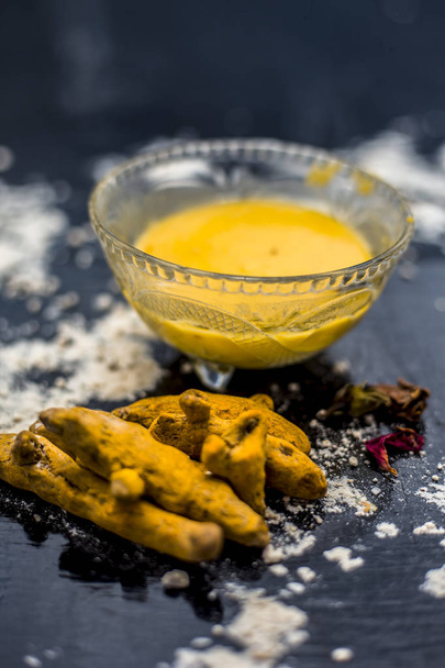 chickpea flour mixed with turmeric and rose water in glass bowl on table for making gram flour face mask for maintaining the pH of the skin - Фото, изображение