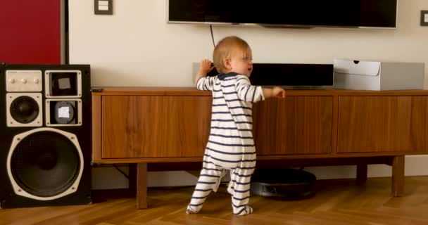Baby in overalls staand in woonkamer - Video