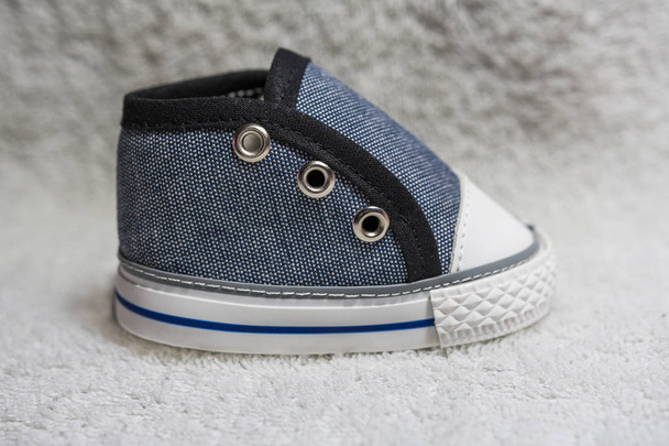 Sapato de bebê azul e preto no fundo branco
 - Foto, Imagem