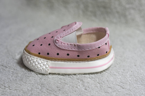 Sapato de bebê rosa no fundo texturizado branco
 - Foto, Imagem