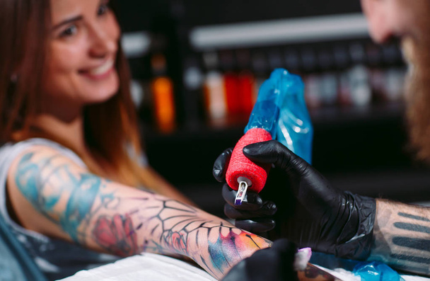 Professional tattoo artist makes a tattoo on a young girls hand. - 写真・画像