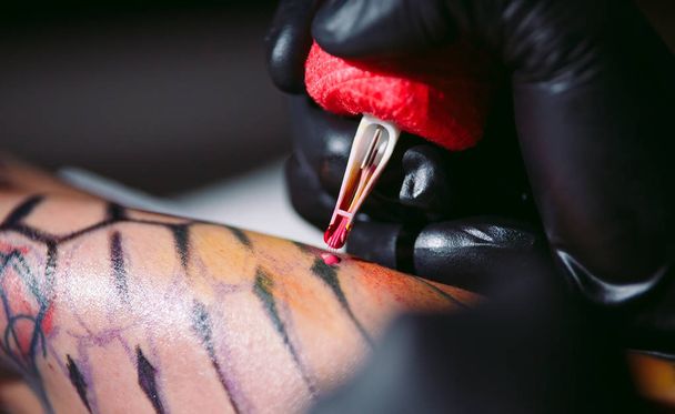 Profi tetováló művész csinál egy tetoválás egy fiatal lány kezét. - Fotó, kép