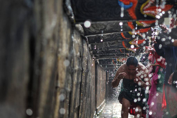 Nepalese devotees take a holy bath from Bais dhara, during Baisdhara festival in Kathmandu, Nepal. It believes that taking a holy bath on this day purifies one spiritually and rid skin diseases. - Valokuva, kuva
