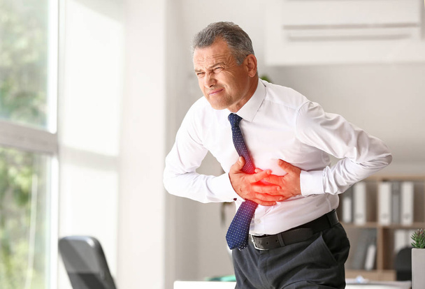 Uomo maturo che soffre di infarto in ufficio
 - Foto, immagini