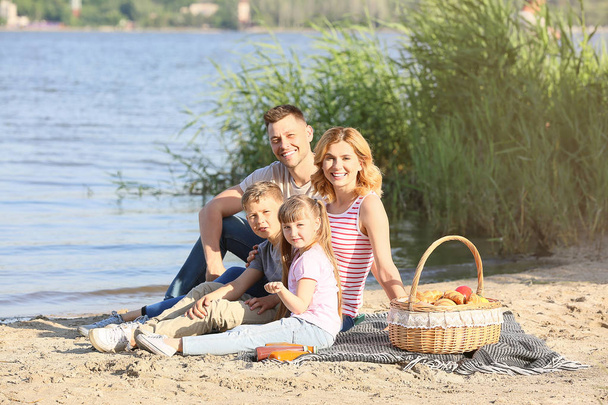 Bonne famille en pique-nique d'été près de la rivière
 - Photo, image