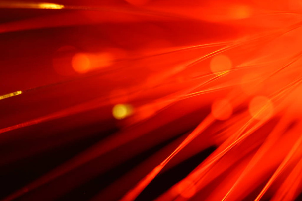 Close up on the ends of a selection of illuminated red fiber optic light strands - Фото, изображение