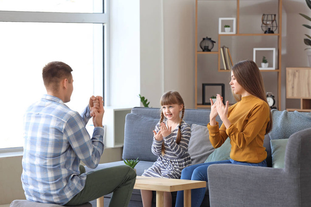 Familia muda sorda usando lenguaje de señas en casa
 - Foto, imagen