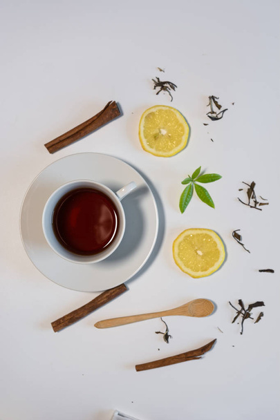 Black tea with lemon and cinnamon. - Фото, зображення