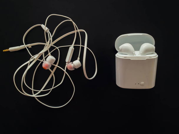Comparison between tangled wired headphones versus wireless earp - Photo, Image