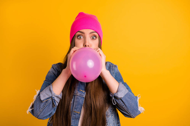 Close up photo beautiful she her lady very long hairstyle hands arms lips air balloon guest birthday surprise big eyes hide half face wear casual jeans denim jacket pink hat isolated yellow background - Foto, imagen