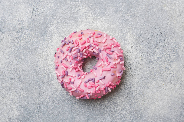 Pink doughnut on a grey background. Top view Flat lay. - Foto, imagen