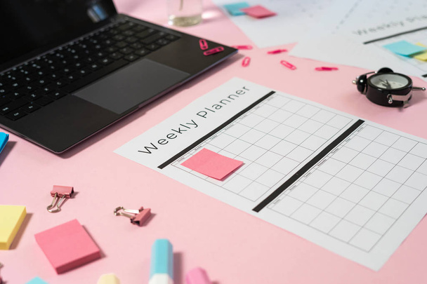 Laptop, stationery and planner on pink pastel background - Photo, Image