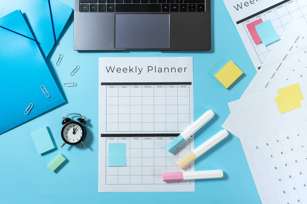 Laptop, cancelleria e planner su sfondo blu pastello
 - Foto, immagini