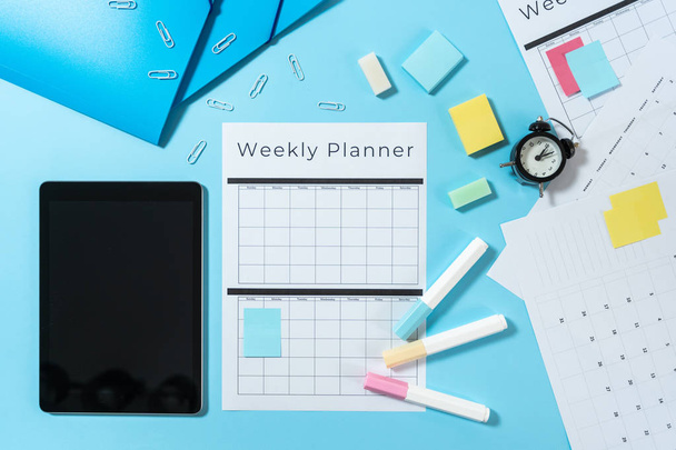 Digitale Tablet, briefpapier en planner op blauwe pastel achtergrond - Foto, afbeelding