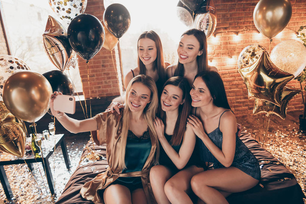 Photo portrait of positive pretty attractive nice fascinating ladies in short clothes costumes sitting on golden shiny king size beddings make selfie having best night evening fest perfect mood - Fotó, kép