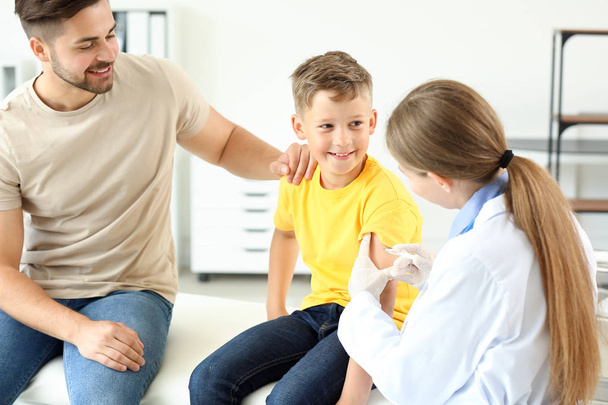Doctor vaccinating little boy in clinic - Zdjęcie, obraz