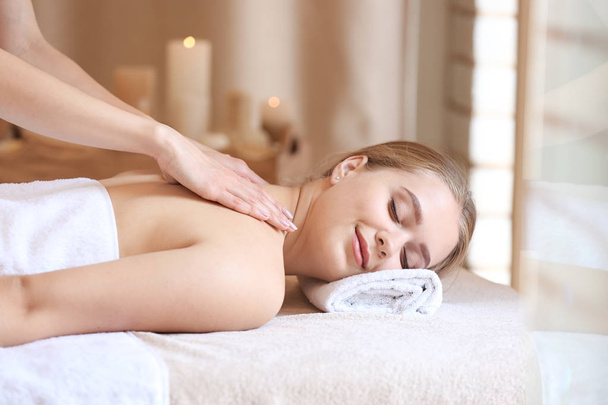 Bella giovane donna che riceve un massaggio nel salone spa - Foto, immagini
