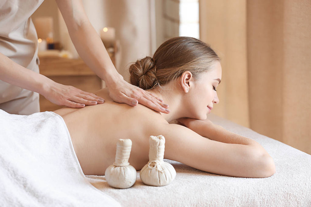 Bella giovane donna che riceve un massaggio nel salone spa - Foto, immagini