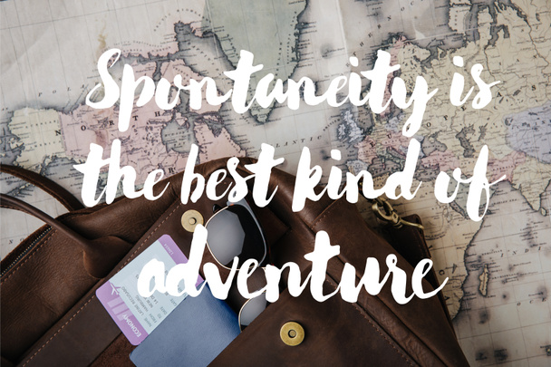 felülnézet bőr táska útlevél, jegy, napszemüveg és Térkép spontaneitás a legjobb fajta kaland illusztráció - Fotó, kép