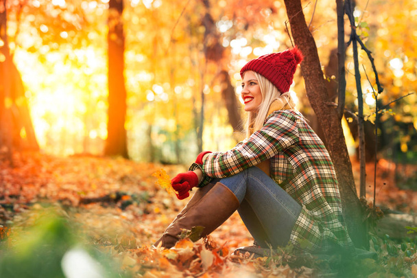 woman sitting in autumn park and enjoy in beautify nature - Foto, Imagen