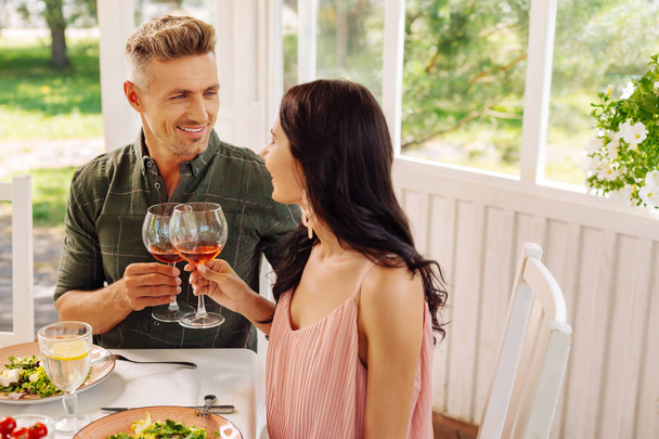 Handsome man looking at his beautiful wife while drinking wine - Valokuva, kuva