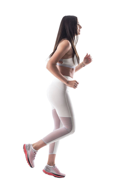 Seitenansicht einer jungen, fitten Joggerin, die einen gesunden Lebensstil führt. Ganzkörper isoliert auf weißem Hintergrund.  - Foto, Bild