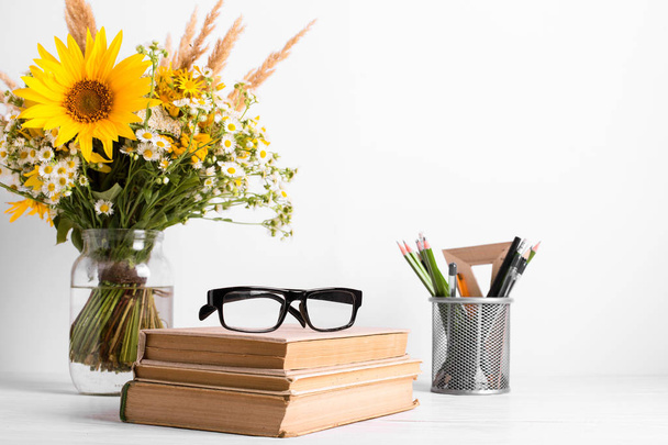 Summer bouquet of wildflowers in glass vase, old books on rustic background. Season design concept. Teachers day concept, back to school. - Fotografie, Obrázek