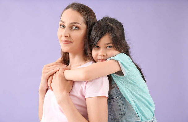 Portrait of happy mother with daughter on color background - Valokuva, kuva