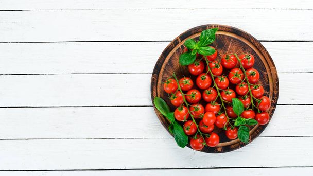 Cherry tomatoes on a white wooden background. Top view. Free space for your text. - 写真・画像