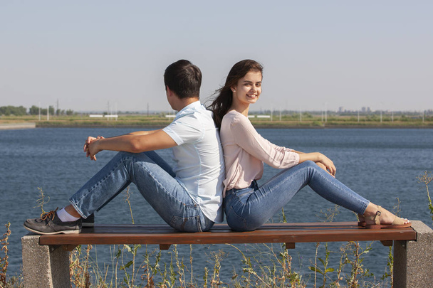 beautiful young couple sitting on a bench in the park - Foto, afbeelding