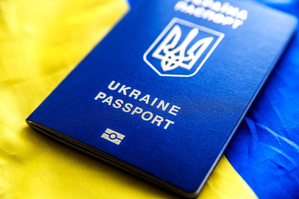 Ukrainan kansalaisen biometrinen passi Ukrainan kansallisen sinikeltaisen lipun taustalla
. - Valokuva, kuva