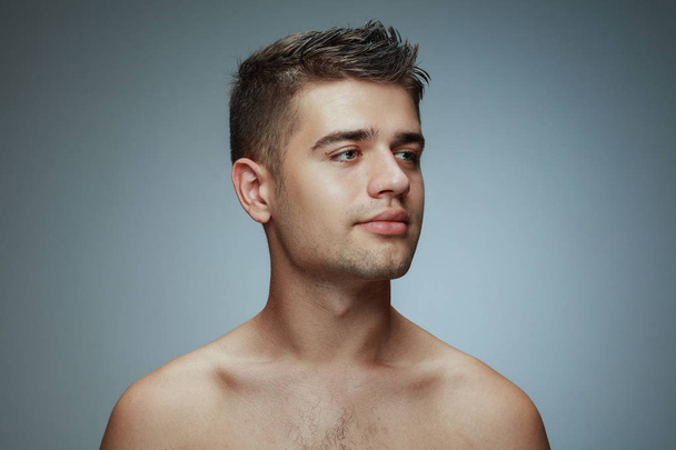 Портрет молодого человека без рубашки, изолированного на сером фоне студии
 - Фото, изображение