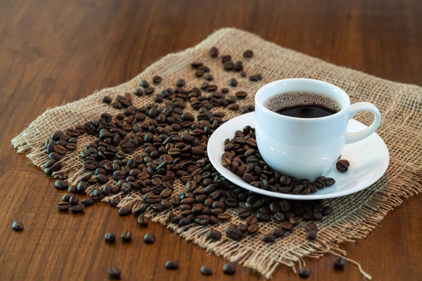Xícara de café quente com grãos de café torrados
 - Foto, Imagem