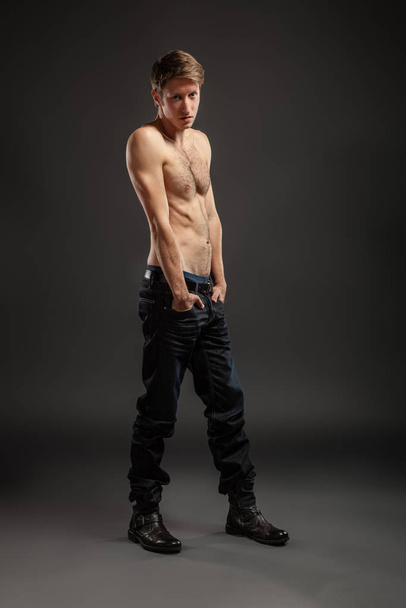 Full length portrait of a sexy young man in jeans and shirtless posing at studio. - Fotoğraf, Görsel