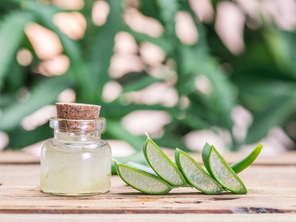 Fresh aloe leaves and aloe gel in the cosmetic jar on wooden tab - Photo, Image