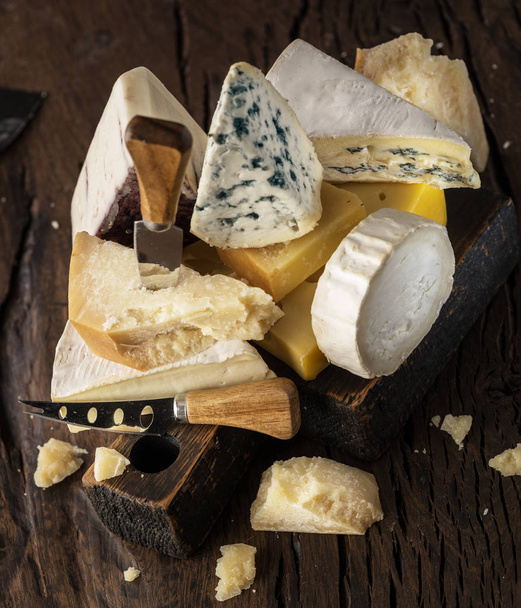 Assortment of different cheese types on wooden background. Chees - Zdjęcie, obraz