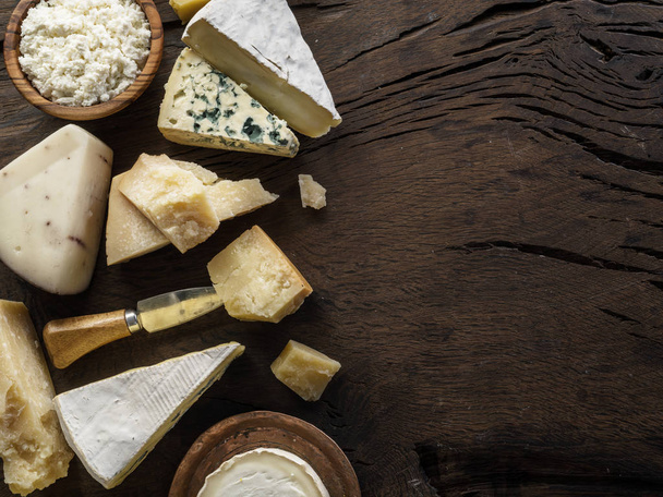 Assortment of different cheese types on wooden background. Top v - Fotoğraf, Görsel