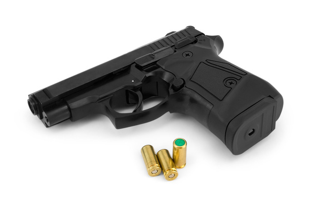 Close-up van een zwart leeg afvuren pistool en lege cartridges, iso - Foto, afbeelding