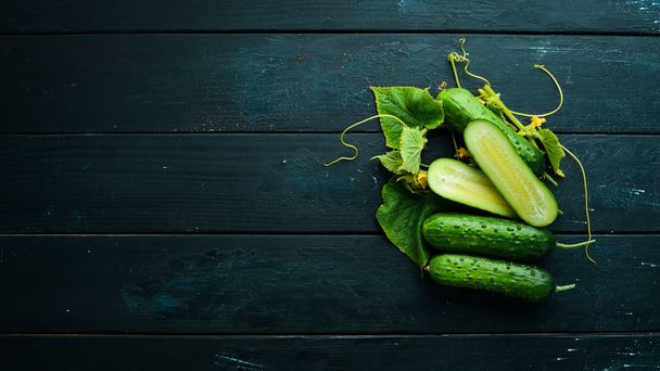 Sliced fresh green cucumbers. On a black background. Top view. Free space for your text. - Foto, Imagem