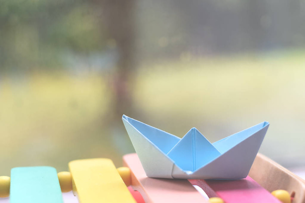 Origami boat by a window on a rainy day inside the house - Photo, image