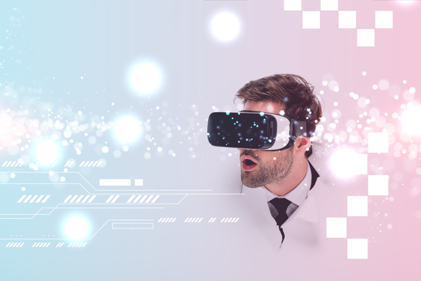 шокований чоловік у гарнітурі віртуальної реальності за дірою в стіні з блискучою ілюстрацією кіберпростору
 - Фото, зображення