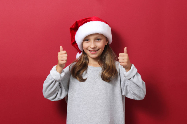 jovencita con un fondo de color en el sombrero de Navidad - Foto, imagen