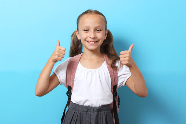Cute smiling schoolgirl with a school backpack on a colored background. Back to school concept - Foto, imagen