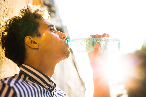 fiatal ember iszik víz kívül  - Fotó, kép