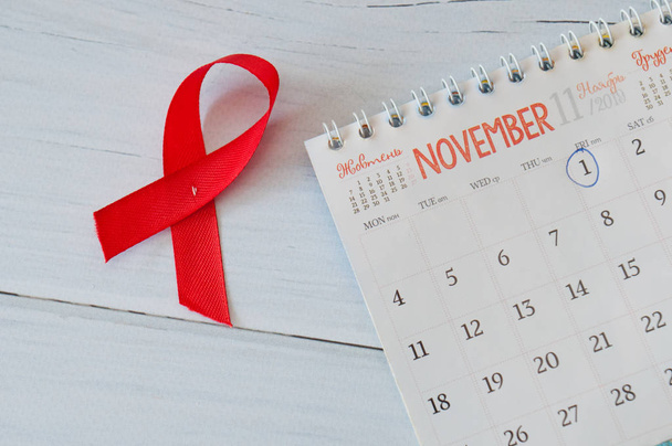 Παγκόσμια ημέρα AIDS. Κόκκινο και ημερολόγιο σε ανοιχτόχρωμο ξύλινο φόντο - Φωτογραφία, εικόνα