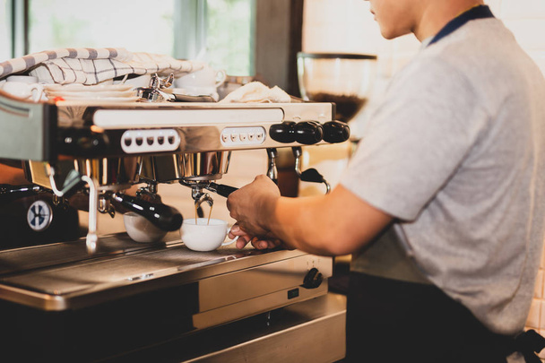 Erkek barista müşteri için kahve hazırlama. - Fotoğraf, Görsel